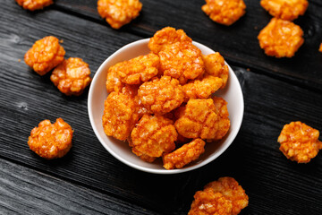 Spicy chilli rice crackers in white bowl. Party food snacks