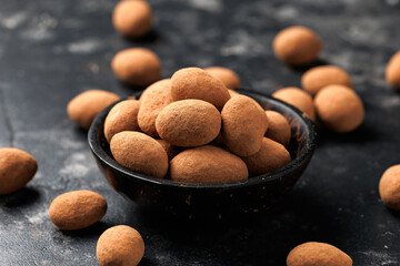 Chocolate coated almonds in bowl. Cocoa coated almonds. Cocoa Dusted Almonds