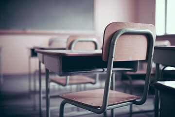 Close-up of empty school desks and chairs, showcasing a simple classroom setting, symbolizing education, learning, and knowledge