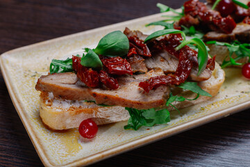 Appetizing sandwiches with meat, greens and berries on a plate.Snack for alcoholic drinks. close-up