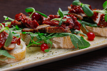 Appetizing sandwiches with meat, greens and berries on a plate.Snack for alcoholic drinks. White bread
