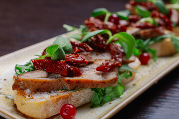Appetizing sandwiches with meat, greens and berries on a plate.Snack for alcoholic drinks. appetizing kind of food