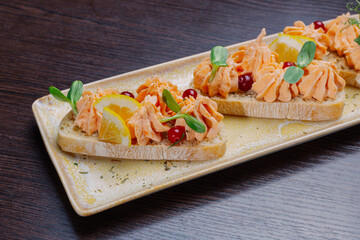 White bread sandwiches with fish cream and herbs on a white plate. appetizer for wine.close-up
