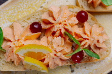White bread sandwiches with fish cream and herbs on a white plate. appetizer for wine. beautiful design of the dish. new trend. appetizing kind of food
