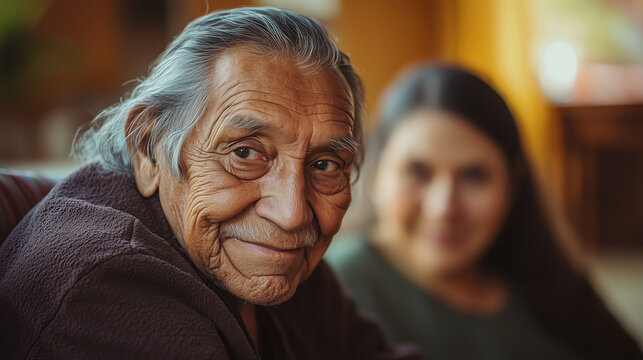 Smiling senior Native American Indian man, younger woman in the background