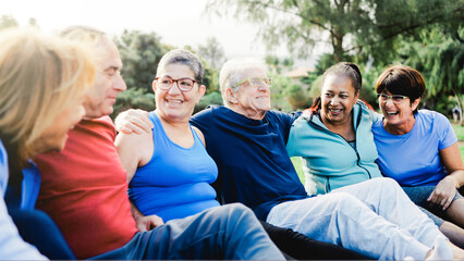 Senior friends, Happy older people have fun after yoga sport class sitting on grass at Park city. Healthy lifestyle
