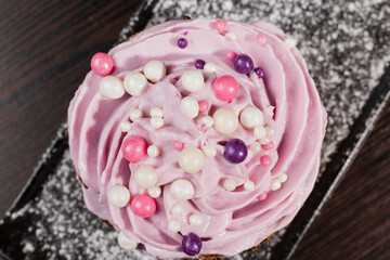 Appetizing fresh dessert cake on a black plate decorated with air cream and cake decorations sprinkled with powdered sugar. sweet dessert from the best confectioner in the city. cream top view