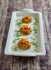 pecan crusted crab cakes topped with bell pepper and green onion