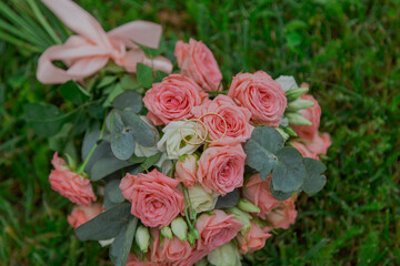 A beautiful wedding bouquet of fresh flowers lies on the green grass wedding day. beautiful pink flowers