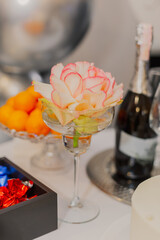 Beautiful bouquet of roses in a glass of cocktail on a covered table for a holiday