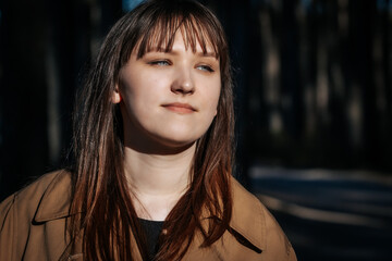 Sharp close-up of a womans face with bright blue eyes, subtle makeup, and a soft expression,...
