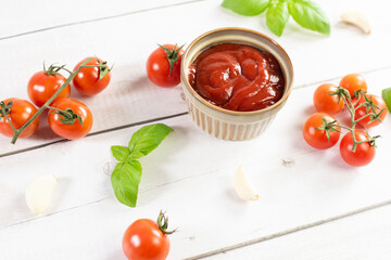 Tomato paste, sauce, ketchup and cherry tomatoes on branches and basil