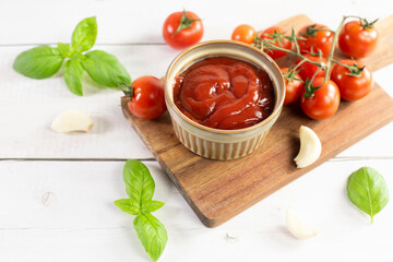 Tomato paste, sauce, ketchup and cherry tomatoes on branches and basil