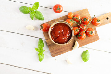 Tomato paste, sauce, ketchup and cherry tomatoes on branches and basil