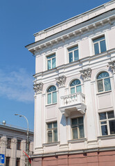 Obraz premium The angle of the facade of the old building that was built 100 years ago against the backdrop of the blue sky