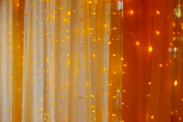Curtains near the window of the institution illuminated by yellow LEDs