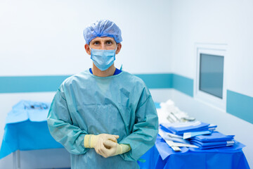 Surgeon gets ready for surgery. A surgical professional in scrubs, gloves, and a mask stands ready...
