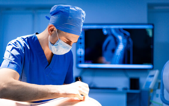 Surgeon at modern clinic. A skilled surgeon in scrubs and mask operates with precision in a well-equipped medical facility, focusing on a patient.