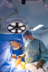Surgeons in action at hospital. Two surgeons are engaged in a procedure, focused and precise, under...