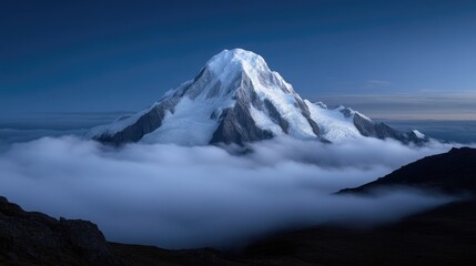 Fototapeta premium Majestic mountain peak piercing through a sea of clouds. A breathtaking vista of a snow-capped mountain rising above a thick layer of fog