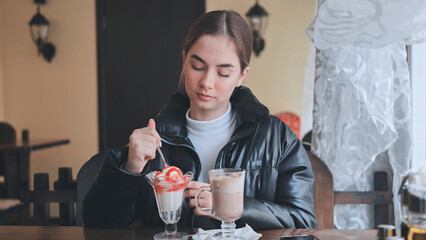Person enjoying sweet treats, sipping warm beverage at rustic cafe table