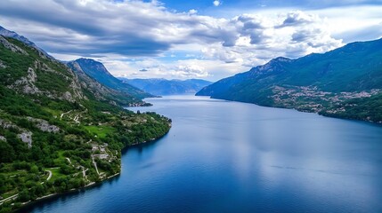 Stunning aerial view of serene lake surrounded by lush green mountains under a bright blue sky : Generative AI