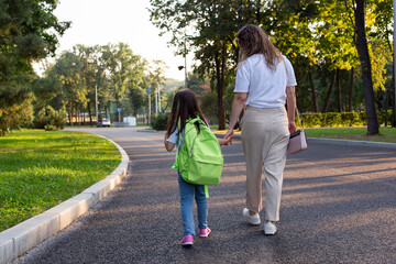 Obraz premium Mother and daughter walking in park: quality time on a sunny day