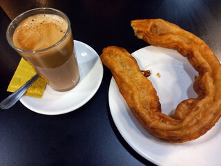 Traditional spanish breakfast with churros and coffee on a black table setting. Typical spanish...