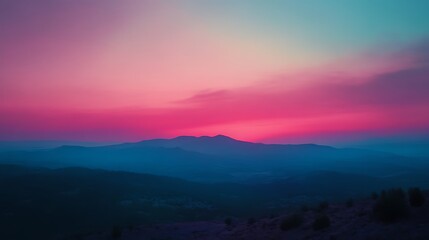 Obraz premium A serene sunset over mountains, blending pink and blue hues in a tranquil landscape.