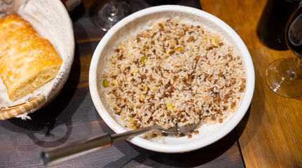 Plate of traditional Middle Eastern dish Mujadara of boiled rice with cooked green lentils and fried onions served for dinner