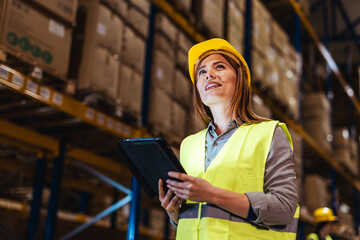 Female Warehouse Worker Using Digital Tablet in Busy Storage Facility