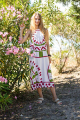 Young woman posing touching oleander flowers in a botanical garden