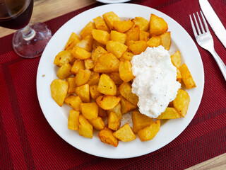 Patatas Bravas, classic Spanish tapas dish, are crispy fried potatoes served with spicy sauce