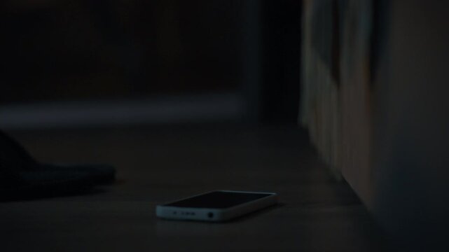 The alarm goes off and the screen of the phone lying next to the bed lights up. The man reaches for it, his fingers instantly turning off the annoying signal. Early morning activities in a room at hom