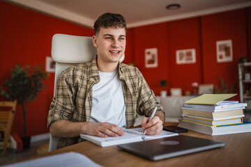 young man student learn and prepare exam from notebook and laptop