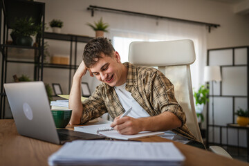 young man student learn and prepare exam from notebook and laptop