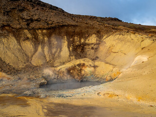 Steaming geothermal pool in Seltún, Krýsuvík, Iceland. Vibrant mineral colors and rising steam illustrate raw geothermal energy and Iceland’s volcanic nature