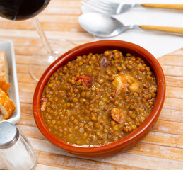 Lentejas con chorizo, beans stewed with chorizo and bacon served on ceramic plate