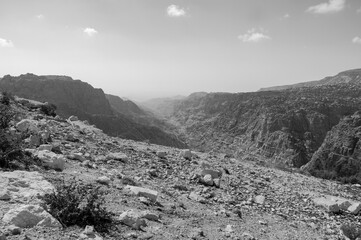 A rocky, barren landscape with a mountain in the background