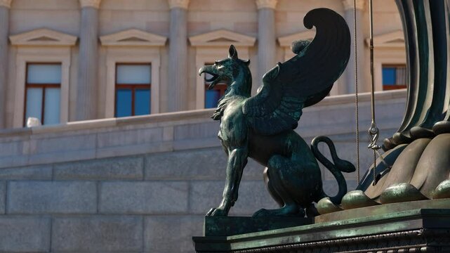 Griffin statue guarding parliament building in vienna. Sunlight casting golden hues on majestic griffin statue, standing sentinel atop stone plinth with historic austrian parliament building