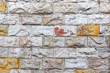 Close-up of textured stone wall with multicolored weathered bricks
