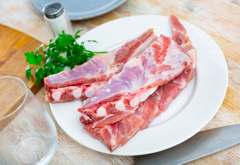Cooking raw pork ribs and parsley on .kitchen table