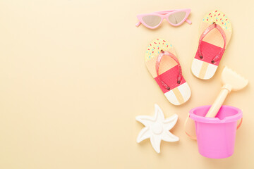 Children's flip flops and beach toys on color background,,top view
