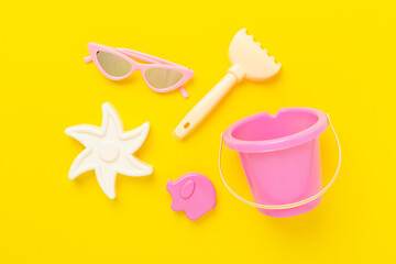 Children's flip flops and beach toys on color background,,top view