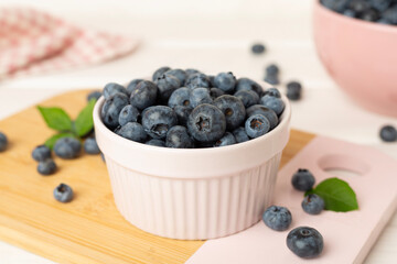 Bowl with fresh bright blueberries on wooden table