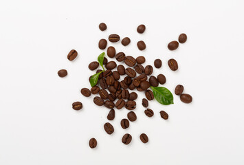 Roasted coffee beans with leaves on white background,top view