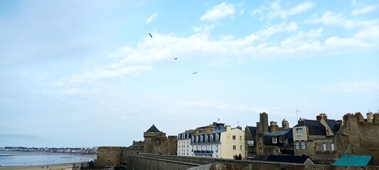 Coastal cityscape with historic buildings under a blue sky  