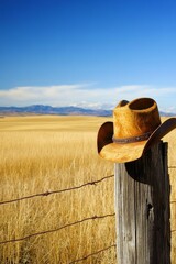 Cowboy hat on fence post prairie landscape