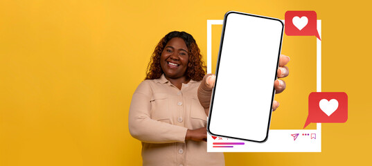 A smiling influencer holds a blank smartphone prominently displaying social media engagement icons. The vibrant yellow background enhances the lively atmosphere, ideal for online chats and messaging.