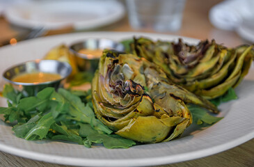 Grilled artichoke halves with sauces, appetizer at a restaurant in Newport Beach